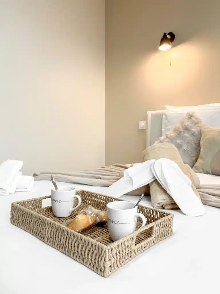 Plateau du petit-déjeuner posé sur un lit blanc, linge plié